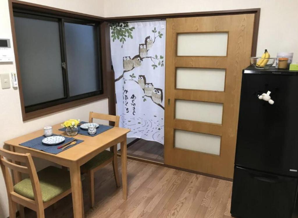 a small kitchen with a table and a refrigerator at ZY House in Osaka