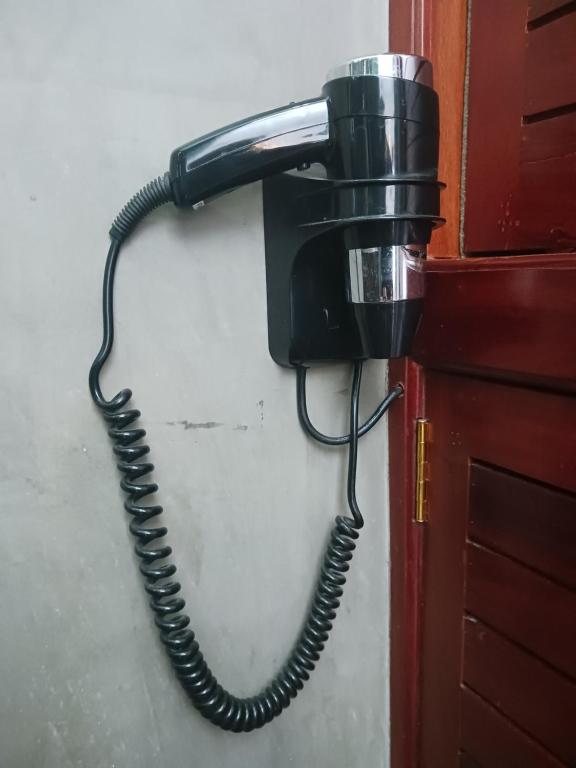 a black phone is hanging on a wall at Andy's Place in Siem Reap
