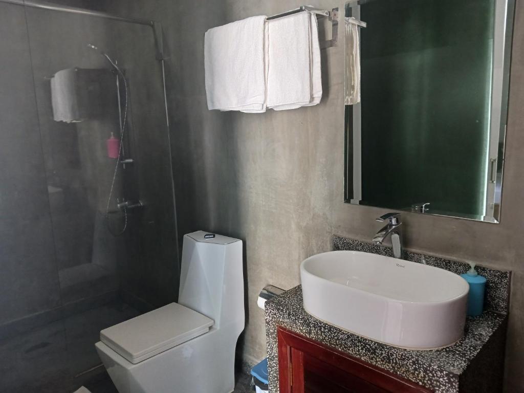 a bathroom with a sink and a toilet and a mirror at Andy's Place in Siem Reap
