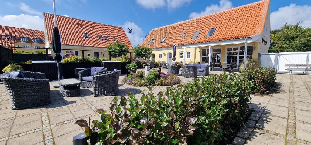a courtyard with chairs and plants in front of a building at Toftegården Guesthouse - Rooms in Skagen