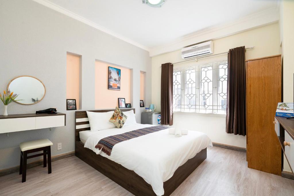 Un dormitorio con una cama grande y una ventana en Planet Homestay en Ho Chi Minh