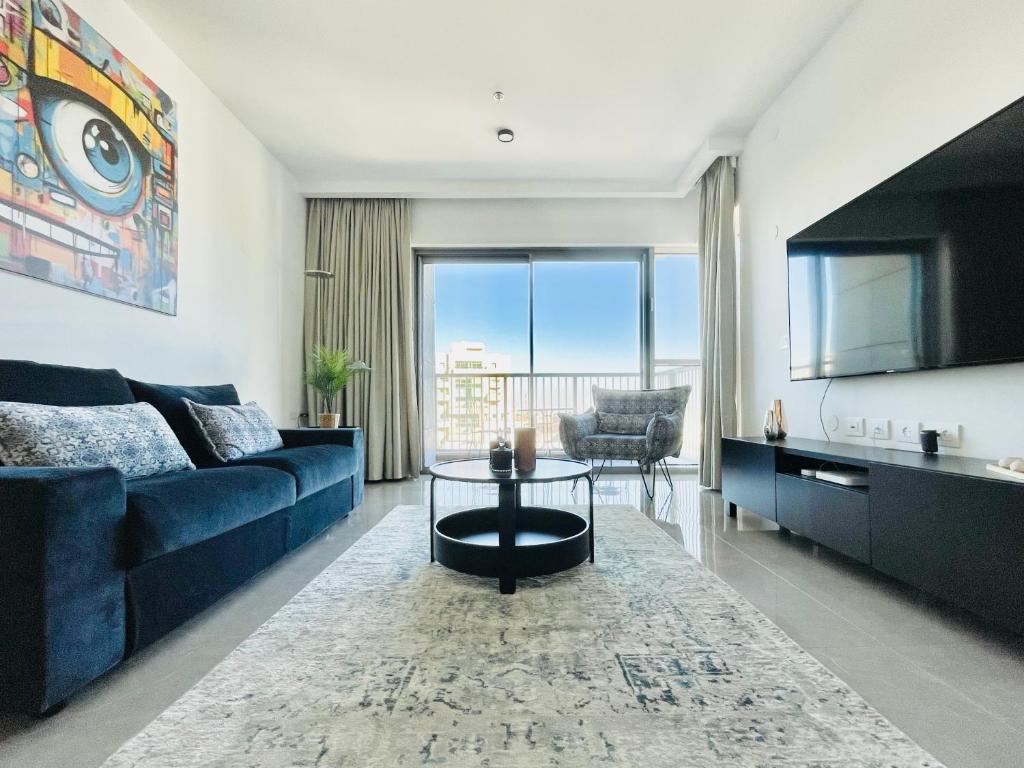 a living room with a blue couch and a table at Savion View Apartment - Jerusalem City Center in Jerusalem