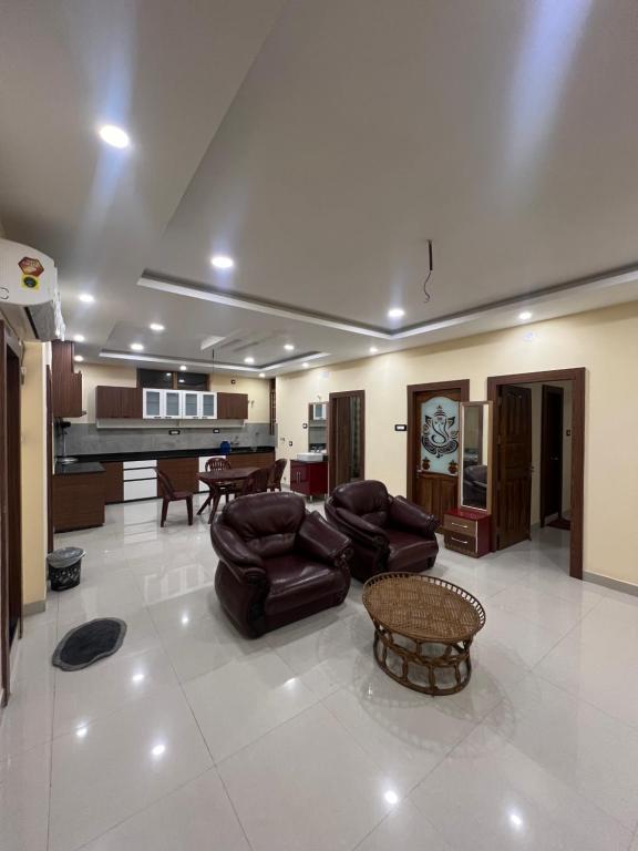 a living room with leather furniture and a piano at Shrinath Palace in Deoghar