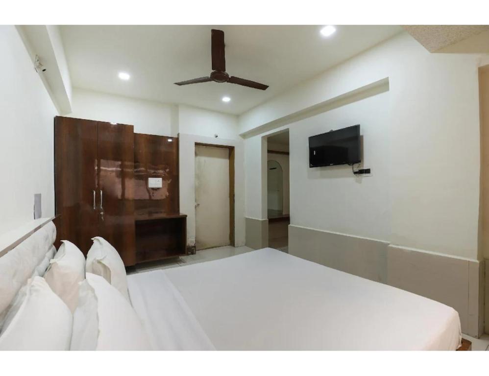 1 dormitorio con 1 cama y TV de pantalla plana en Hotel Janki Guest House, Jamnagar, en Jamnagar