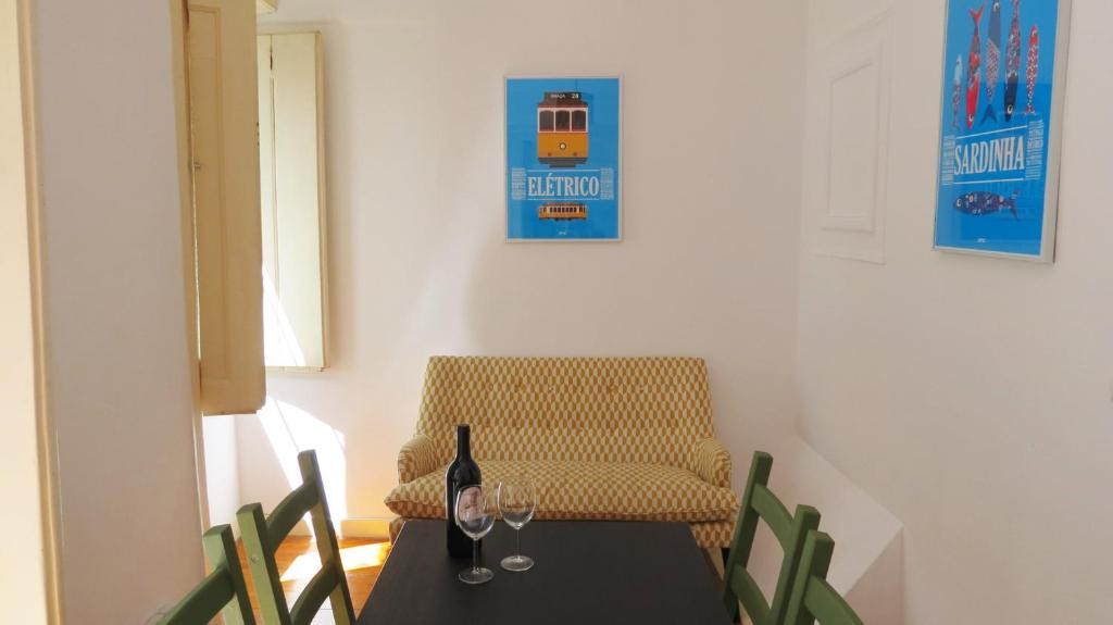 a table with a bottle of wine and a chair at Casa De Baixo in Lisbon