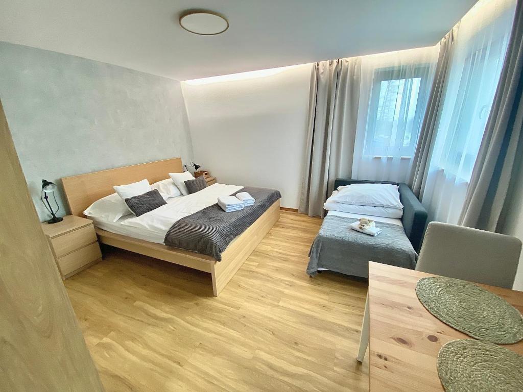 um pequeno quarto com 2 camas e uma cadeira em FamilyFitHouse em Bystrzyca
