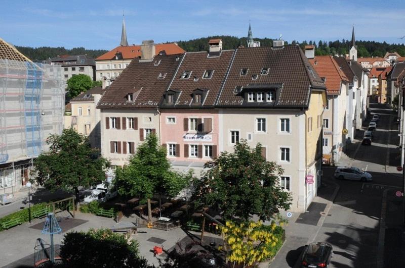 einen Blick über eine Stadtstraße mit Gebäuden in der Unterkunft Chez Gilles hôtel resto bar SA in La Chaux-de-Fonds