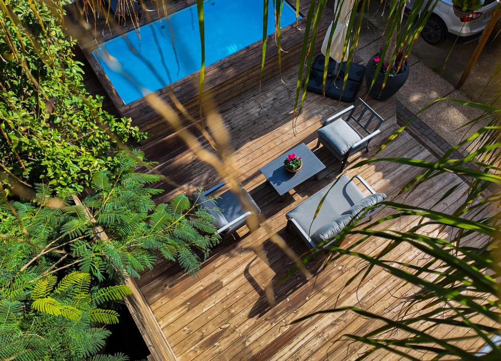 einen Blick über eine Terrasse mit Stühlen und einen Pool in der Unterkunft Villa Rosen at Ramat Hahayal TLV in Tel Aviv