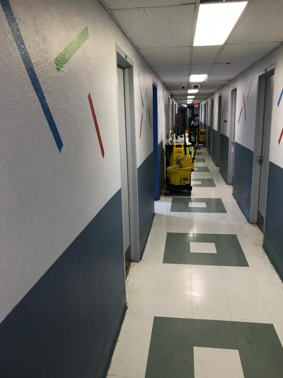 an empty hallway of a hospital with blue and green walls at Sweet Montreal room in Montreal