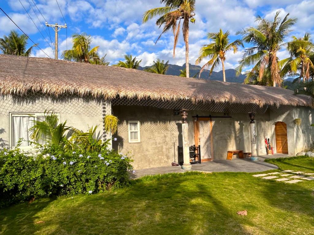 a house with a thatched roof and a yard at 鳳凰懷舊 in Chenggong