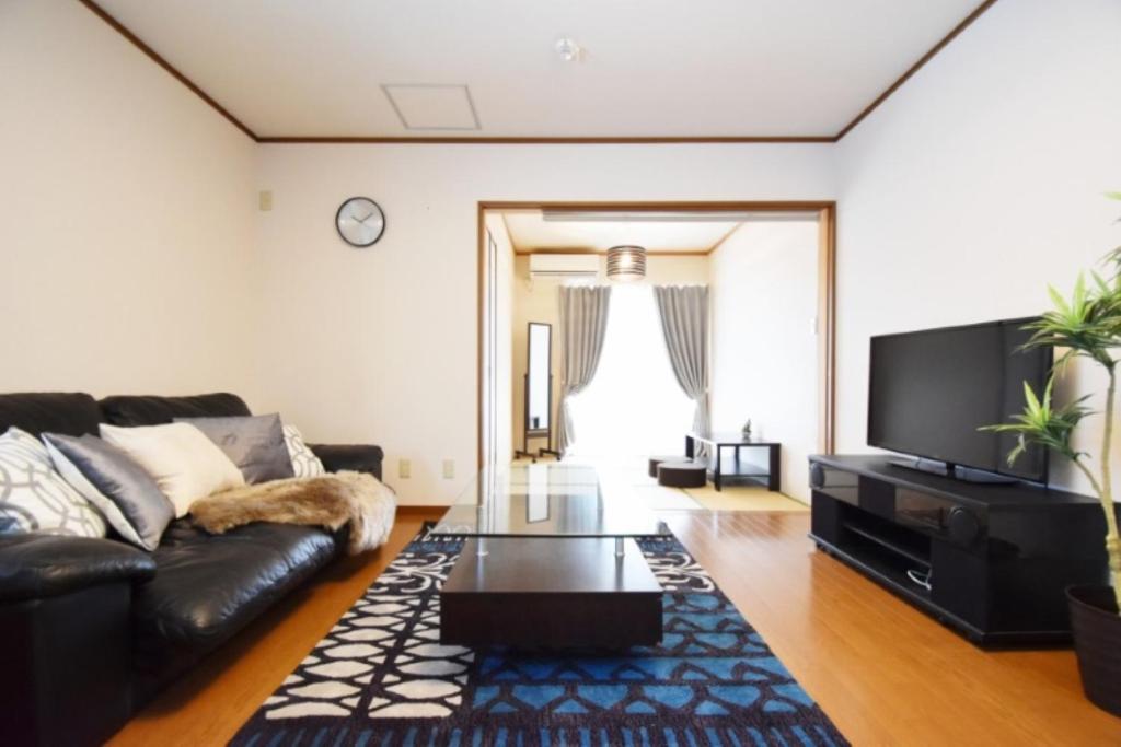 een woonkamer met een bank en een salontafel bij OMOTENASHI in Kyoto