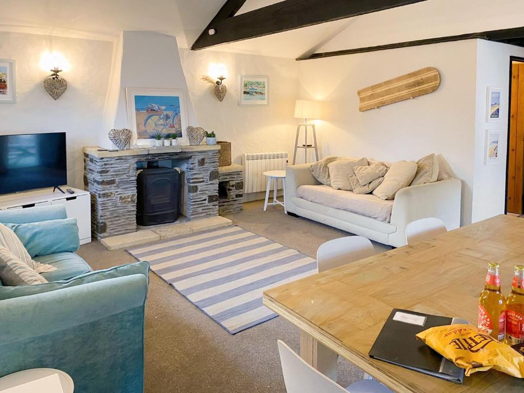 uma sala de estar com um sofá e uma lareira em Pump Cottage em Woolacombe