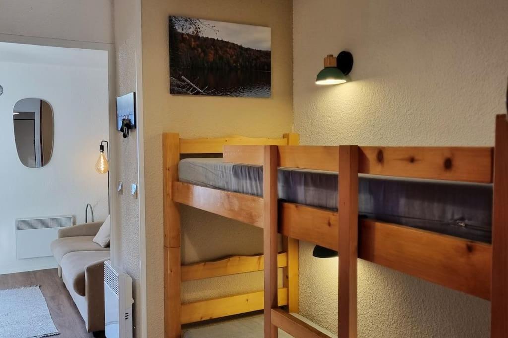 a bedroom with two bunk beds and a couch at Le Montagnard in Mijoux