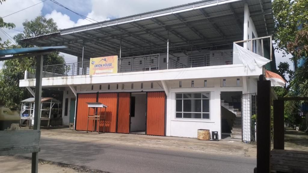 a building with a balcony on top of it at Orion Jaya House in Ketapang