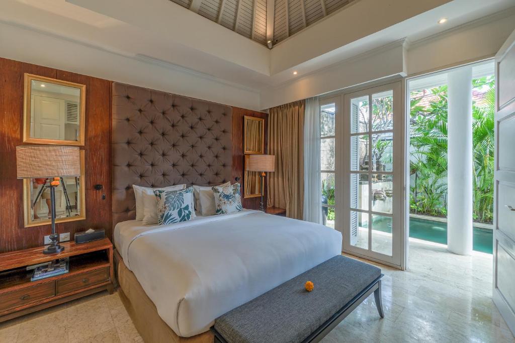 um quarto com uma cama grande e uma janela grande em Mosan House - unique art-filled gem in perfect location a short walk from the beach or Seminyak Square including AC office for remote working em Seminyak