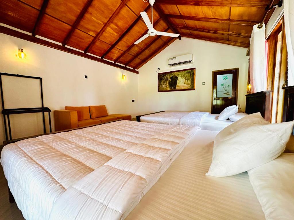 a large bedroom with two beds and a couch at Green Sapphire Holiday Resort Wilpaththu in Wilpattu