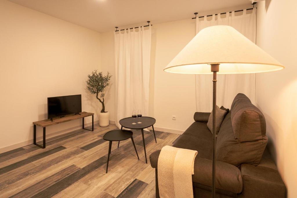 a living room with a couch and a lamp at La casona de Torremocha de Jarama in Torremocha de Jarama