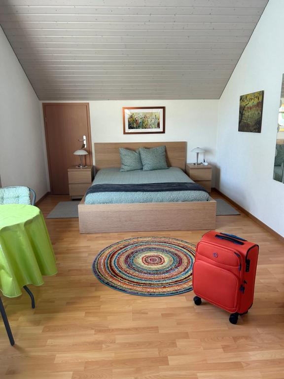 Queen Guest Room في Mont-sur-Rolle: غرفة نوم بسرير وحقيبة حمراء