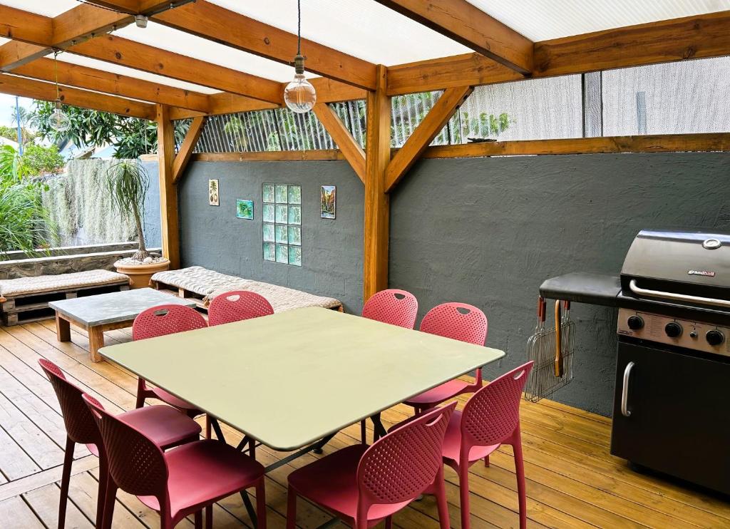 um pátio com uma mesa, cadeiras e comodidades para churrascos em Villa K'nell - La Possession em La Possession