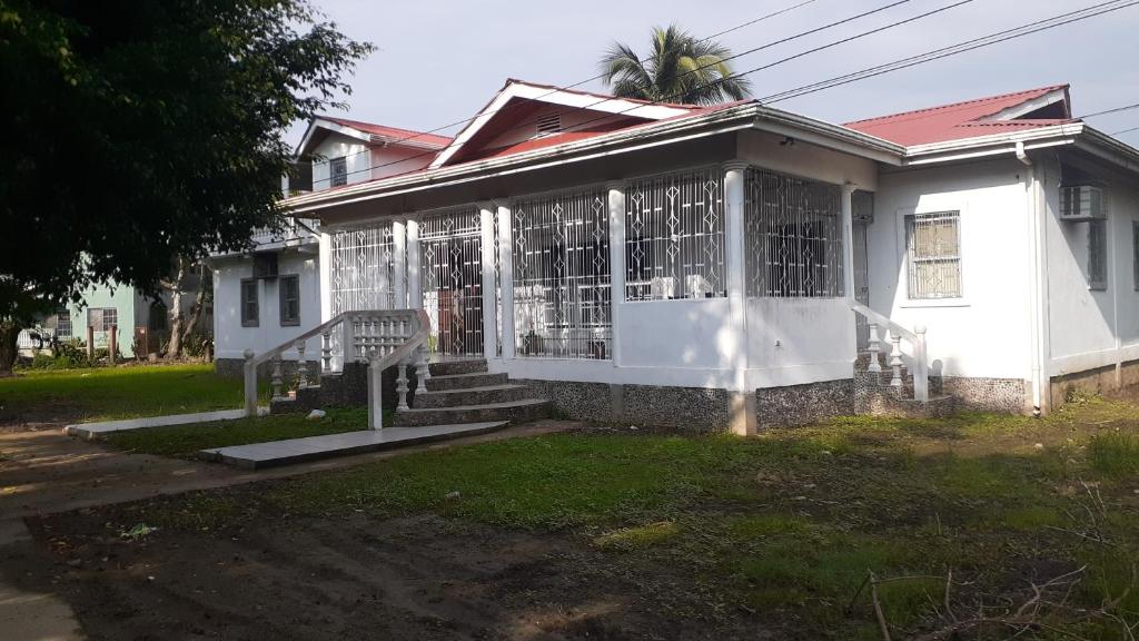 a white house with a palm tree in front of it at La Casa Blanca De Mis Sueños in Tela