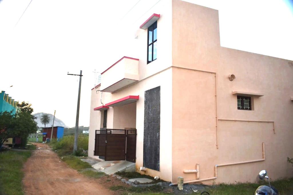 un edificio con una puerta al lado de un camino de tierra en Harisri Homestay, en Madurai