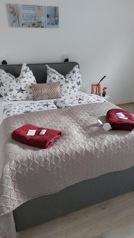 - un lit avec 2 oreillers rouges dans l'établissement Hotel Bei Maria, à Bilstein