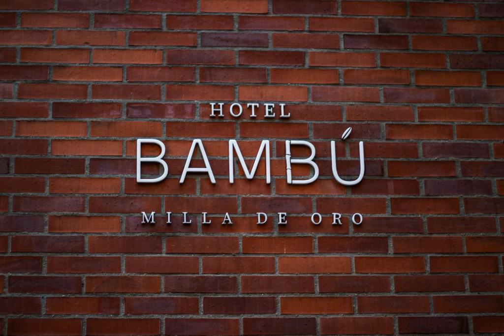 a sign for a hotel on a brick wall at Hotel Bambu Milla De Oro in Medellín