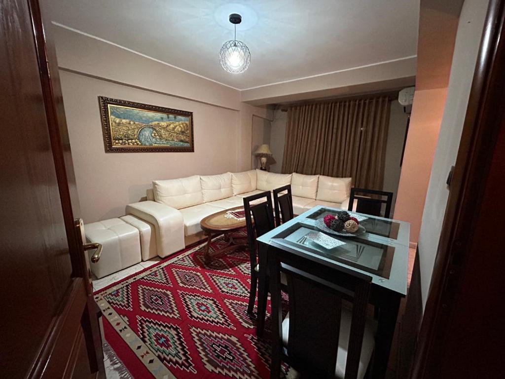 a living room with a white couch and a table at APARTMENT Toxhi in Shkodër