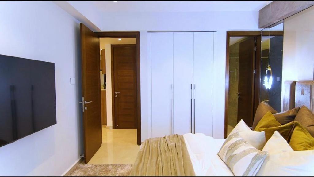 a bedroom with a bed and a tv and a room at Primahem solaris in Accra