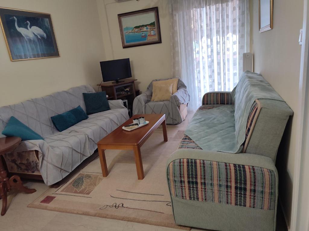 ein Wohnzimmer mit einem Sofa und einem Tisch in der Unterkunft Christie's Apartment in Agrinio