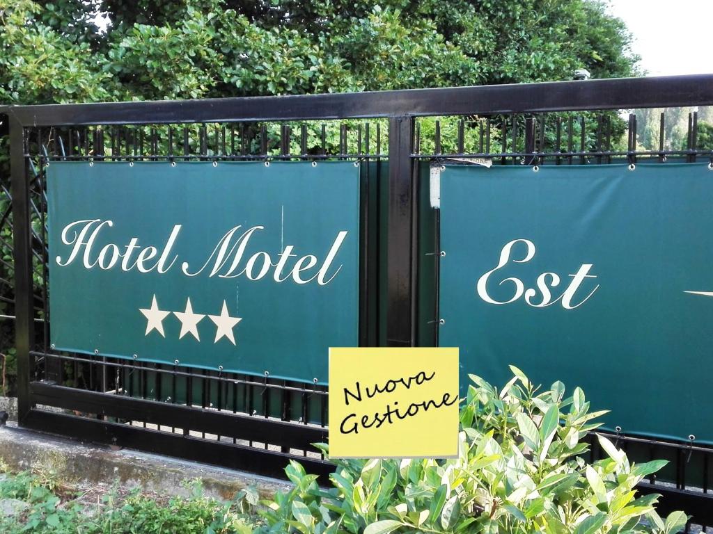 un cartello per un hotel vicino a una recinzione di Hotel Motel Est a Peschiera Borromeo
