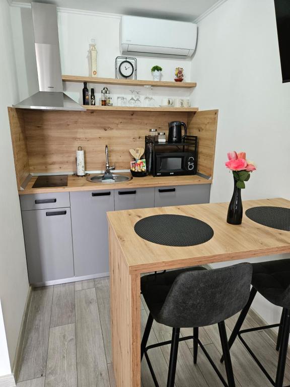 a kitchen with a wooden counter and a table at Studio apartman Antonio in Metković