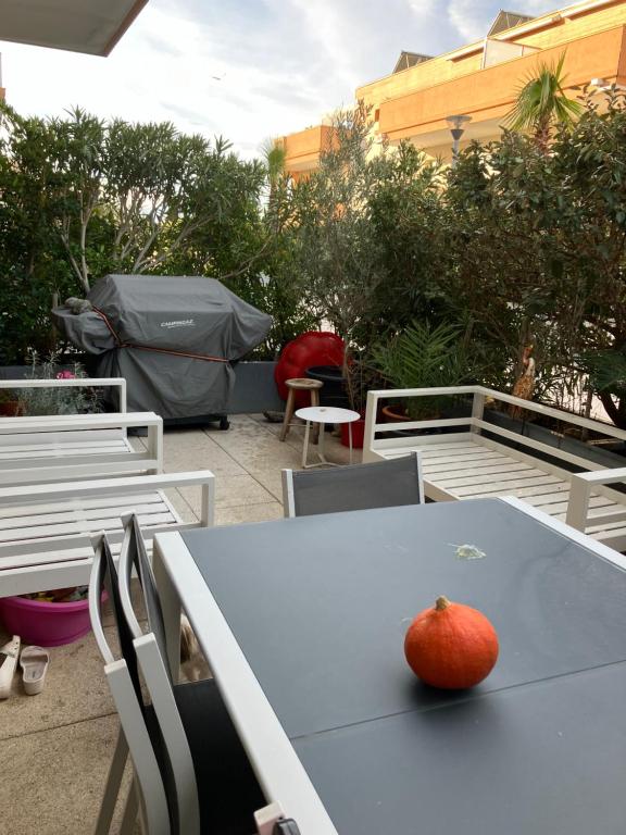 an apple sitting on a blue table with chairs at AppartCanet in Canet-en-Roussillon