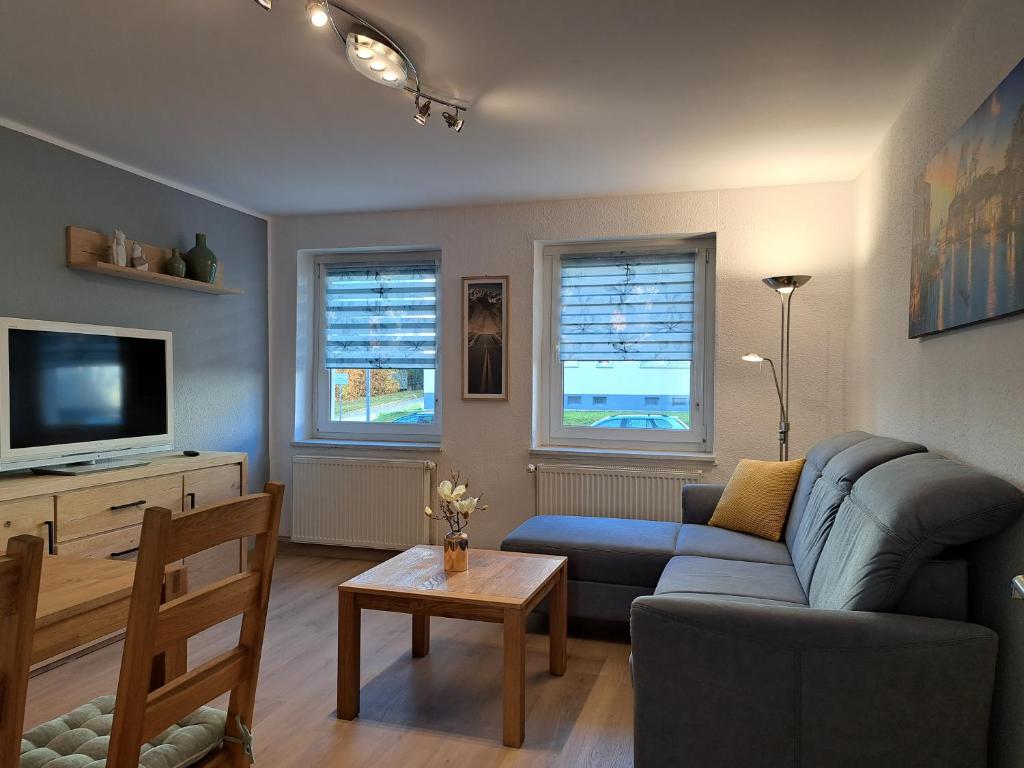 a living room with a couch and a tv at Ferien und Gästewohnung Hettstedt in Hettstedt