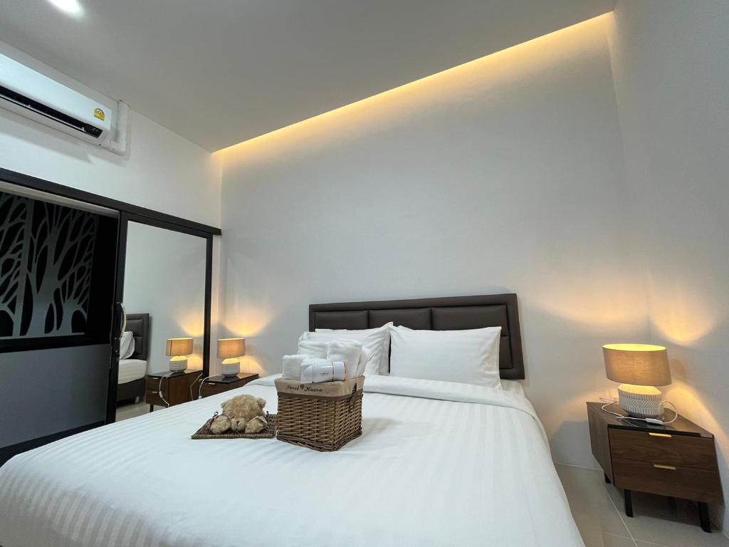 a bedroom with a white bed with a basket on it at DM.Hotel&cafa in Ban Na Tho
