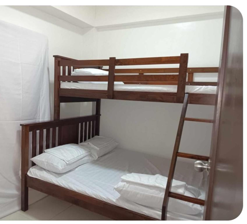 two bunk beds in a room with a ladder at Krystal Claine Homestay-BURNHAM HILL in Baguio