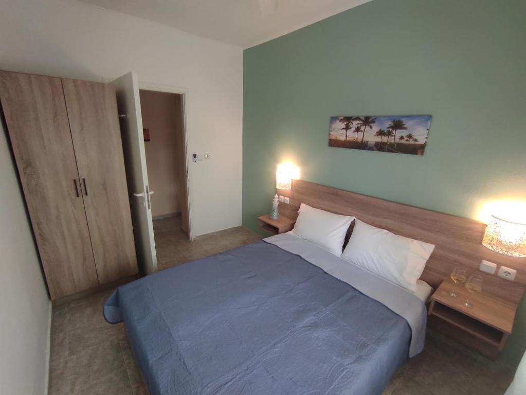 1 dormitorio con cama azul y cabecero de madera en Sunrise Vergia Studio, en Sozopoli