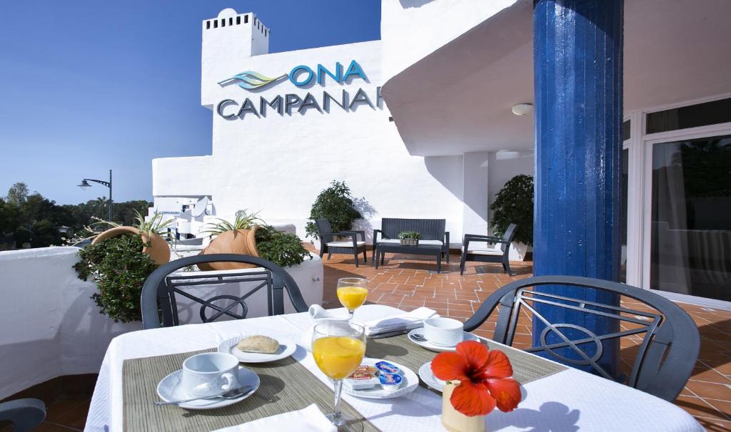 a table with a plate of food and drinks on a patio at Ona Campanario in La Cala de Mijas