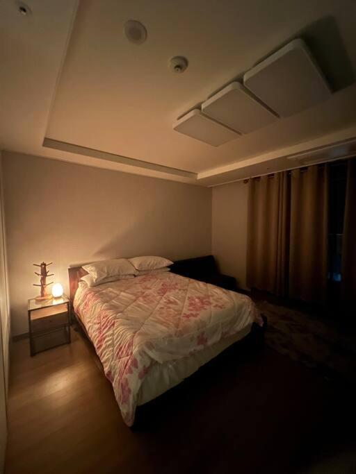 a bedroom with a bed and a lamp on a table at (NEW) Luxury Condo in Clark 