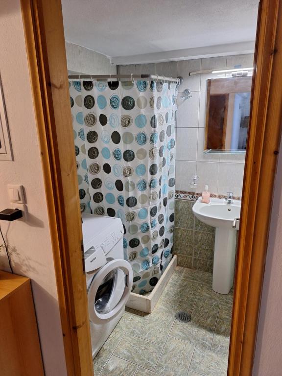 a bathroom with a toilet and a shower curtain at Jim's House in Káspakas