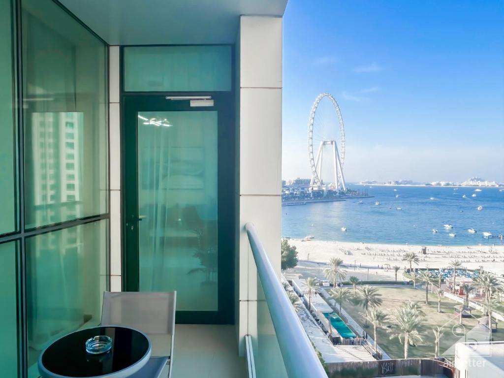 uma vista para a praia a partir de uma varanda de um edifício em Luxurious 1B Seaview Apartment in JBR em Dubai
