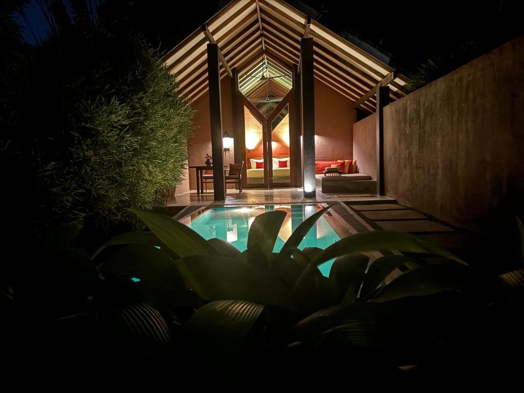 a house with a swimming pool at night at Nisala Villas in Hikkaduwa