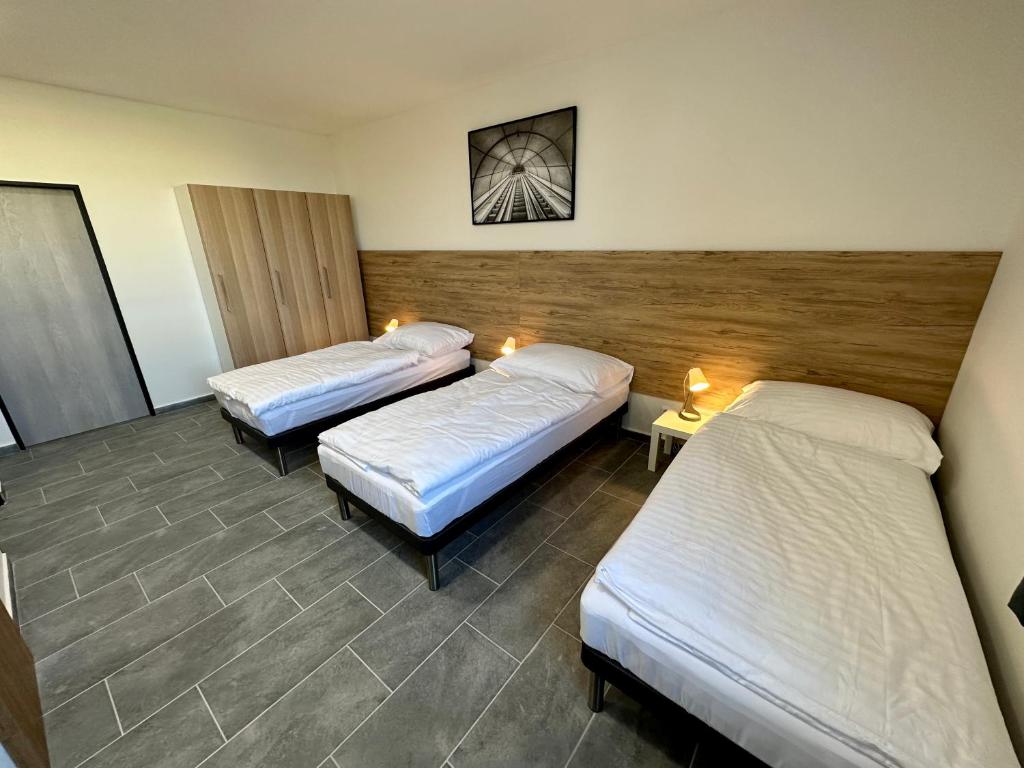a room with three beds in a room at Hotel Hangar in Mošnov