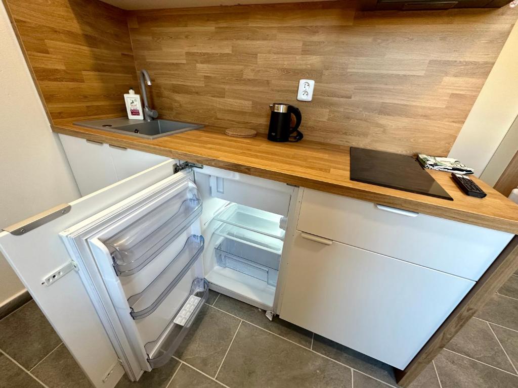 a kitchen with an open refrigerator and a counter at Hotel Hangar in Mošnov