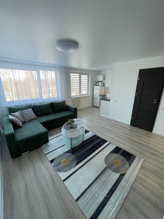 uma sala de estar com um sofá e uma mesa em Apartamentai em Marijampolė
