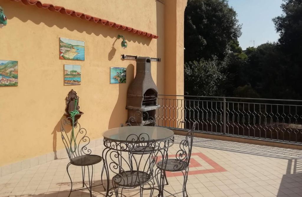 patio con mesa, sillas y horno al aire libre en Casa Verde, en Nápoles
