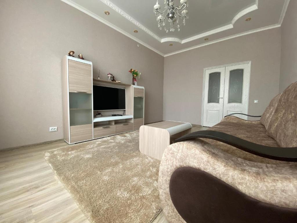 a large living room with a couch and a television at Двухкомнатные бизнес апартаменты в ЖК Заман in Atyraū