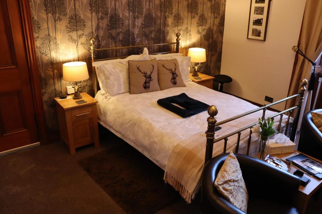 a bedroom with a bed with two lamps and two tables at Gowanlea Heights in Campbeltown