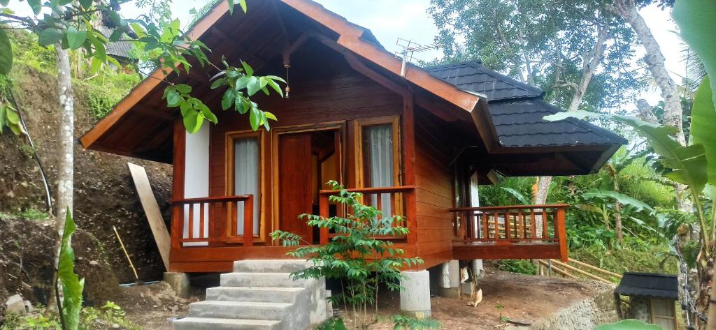 a small wooden house in the middle of a forest at Nea Cottage Lombok in Tetebatu