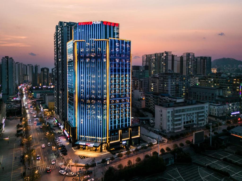 un edificio iluminado en una ciudad por la noche en Intercity Renhuai, en Zunyi
